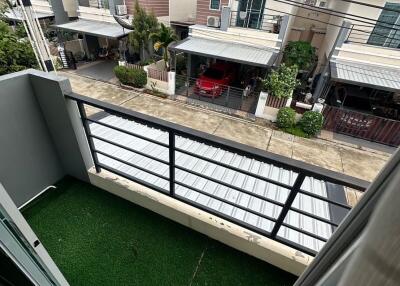Small balcony with artificial grass overlooking residential area