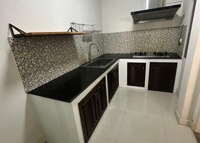 Modern kitchen with tiled backsplash and stainless steel hood