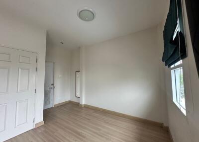 Empty bedroom with wooden flooring and window with blinds