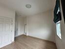 Empty bedroom with wooden flooring and window with blinds