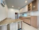 Modern kitchen with marble countertops and wooden cabinets