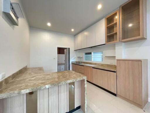 Modern kitchen with marble countertops and wooden cabinets