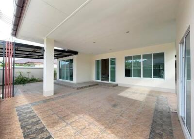 Spacious outdoor covered area with tiled flooring and sliding glass doors