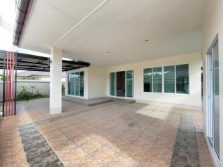 Spacious outdoor covered area with tiled flooring and sliding glass doors