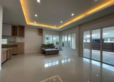 Spacious living area with modern lighting and large glass doors opening to a patio