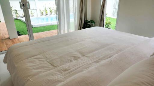 A bedroom with a view of the pool and garden