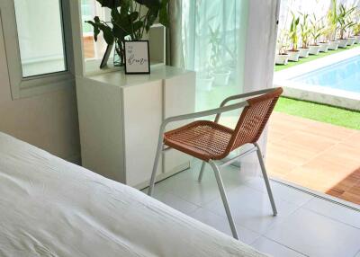 A bright bedroom with a view of the pool