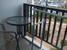 Balcony with a small round table, chair, and a clothes drying rack