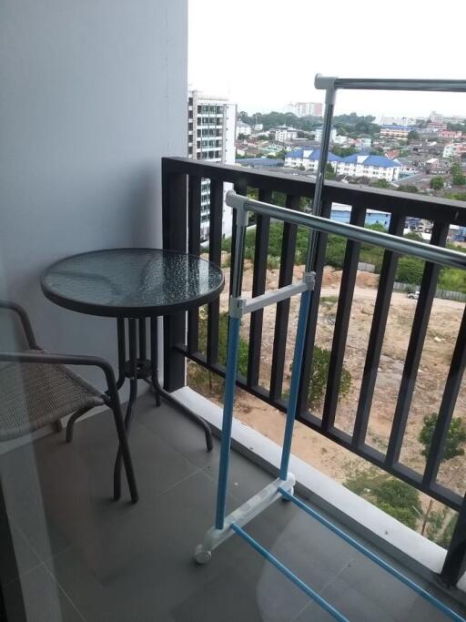 Balcony with a small round table, chair, and a clothes drying rack