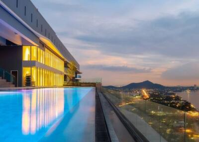 Rooftop pool with a scenic city and mountain view at sunset