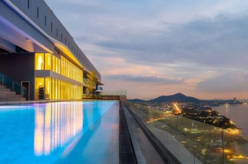 Rooftop pool with a scenic city and mountain view at sunset
