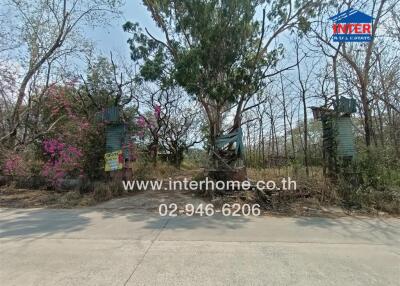 Entrance of a property with trees and a sign