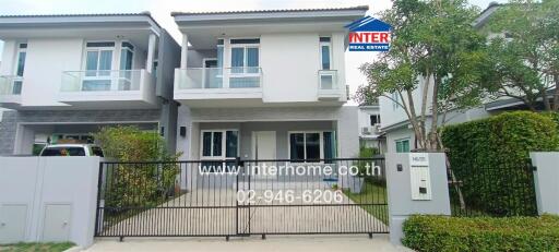 Modern two-story residential house with a front yard and driveway