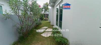 Small garden area with pathway beside the house