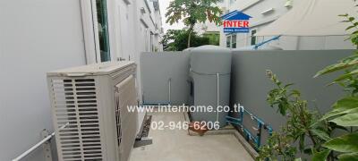 Outdoor utility area with HVAC unit and water tank