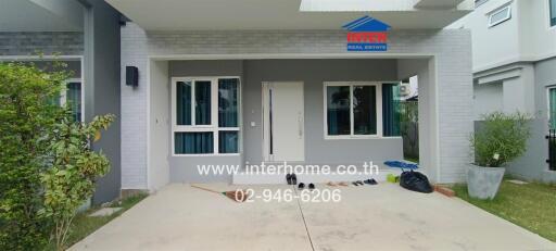 Exterior view of a modern house with a front yard and driveway