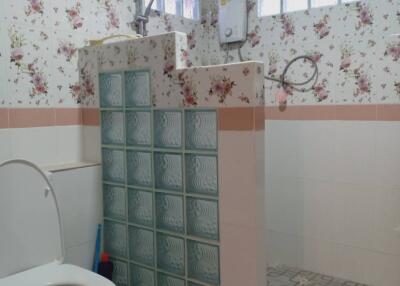 Bathroom with floral wallpaper and glass block partition