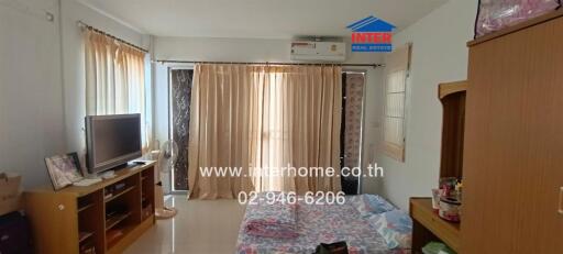 Bedroom with TV, air conditioning, bed and wooden furniture