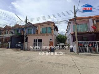 Front view of townhouse with neighboring houses and driveway