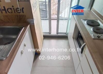 Compact kitchen with appliances and balcony access