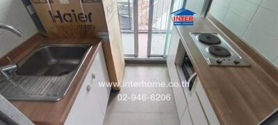 Compact kitchen with appliances and balcony access