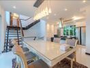 Modern dining area connected to kitchen with contemporary lighting and staircase