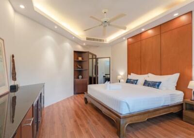 Spacious bedroom with modern lighting and wooden flooring