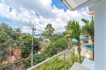 Balcony view with lush greenery and distant sea