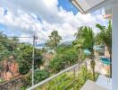 Balcony view with lush greenery and distant sea