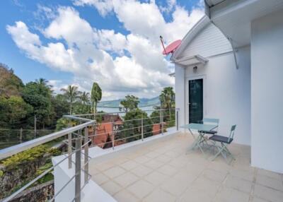 Spacious balcony with outdoor chairs and table, offering scenic views