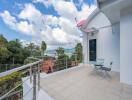 Spacious balcony with outdoor chairs and table, offering scenic views