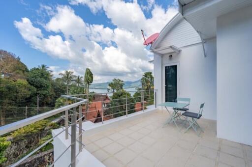 Spacious balcony with outdoor chairs and table, offering scenic views