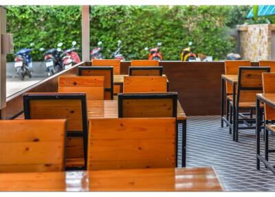 Outdoor seating area with wooden tables and chairs