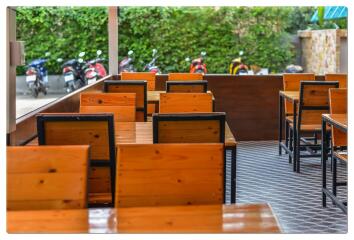 Outdoor seating area with wooden tables and chairs