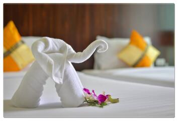 Bedroom with neatly arranged bed and decorative towels with flowers