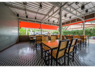 Outdoor dining area with wooden tables and metal chairs