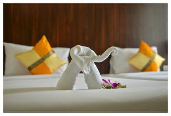 Elegant bedroom with decorative pillows and a towel sculpture on the bed