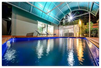 Outdoor swimming pool area with chairs and covered canopy