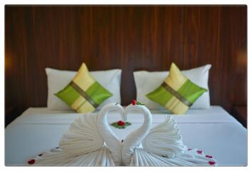 Bedroom with neatly arranged bed and swan towels