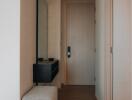 Hallway with a mirror, small black console table and a cushioned bench