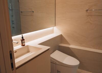 Modern bathroom with large mirror and wall-mounted towel racks