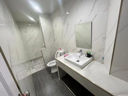 Modern bathroom with a sink, mirror, and a toilet