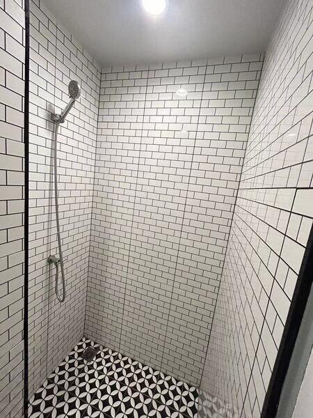 Modern shower with white subway tiles and patterned floor tiles