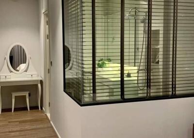 Hallway with view into bathroom and bedroom vanity