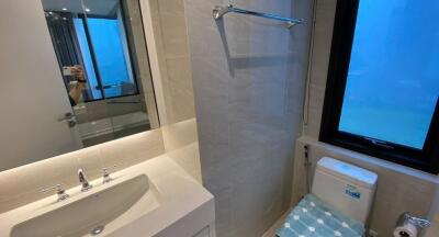 Modern bathroom with sink, mirror, toilet, and window