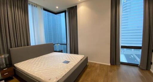 Modern bedroom with large windows and grey curtains