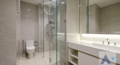 Modern bathroom with glass shower, toilet, and large mirror