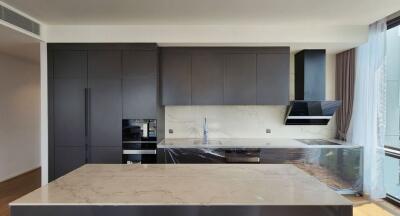 Modern kitchen with marble countertops and dark cabinetry