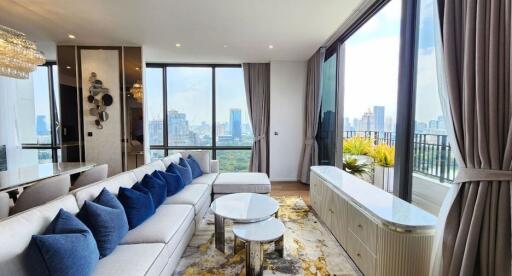 Spacious living room with large windows, modern decor, and city view