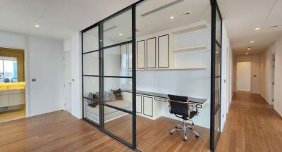 Modern home office with glass partition and built-in desk